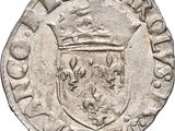 une pièce d'argent surmontée d'une couronne