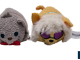 two stuffed animals sitting next to each other on a white surface