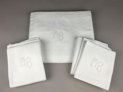 three white towels with monograms on them sitting next to each other