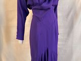purple dress on a mannequin stand against a white backdrop
