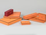 several orange boxes are stacked on top of each other on a white surface