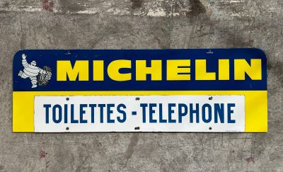 a sign that says michel toilettes telephone on the side of a building