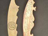 pair of antique brass and copper knifes on a black background