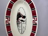 a plate with a picture of a man on a surfboard on it