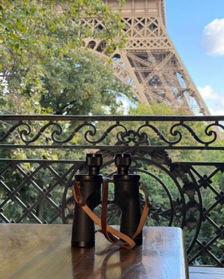 view of the eiffel tower from a balcony with a pair of binoculars