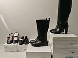 Plusieurs paires de chaussures noires et blanches sont posées sur une pile de cartons