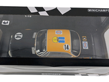 a yellow toy car in a black box on a white background