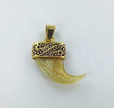 une image représentant un pendentif plaqué or orné d'une corne sculptée