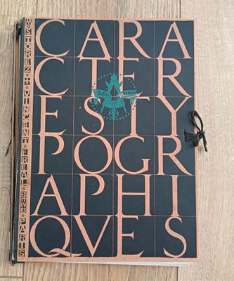 a book on the floor with a pen and glasses on it