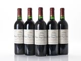 four bottles of wine are lined up in a row on a white surface