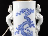 a blue and white vase with a light on it
