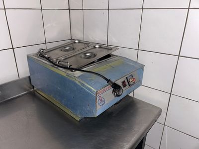 a blue stove sitting on top of a metal counter