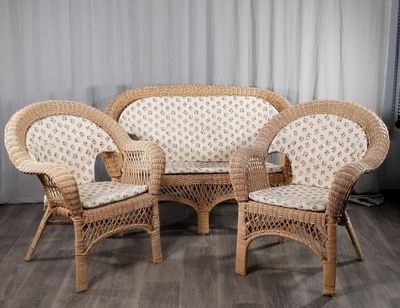 trois chaises en osier et une table dans une pièce avec un rideau blanc