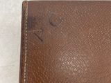 a brown leather wallet sitting on a white surface