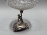 un plateau en argent ancien surmonté d'un bol en verre