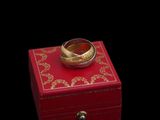 une boîte rouge surmontée d'un anneau doré