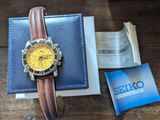 une montre posée sur un portefeuille, à côté d'un livre