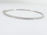un gros plan d'un bracelet à maillons en diamant posé sur une surface blanche