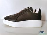 men ' s brown leather sneakers with white soles on a white surface