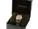 a watch in a black box with a gold band