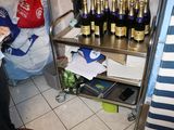 une femme debout devant une étagère où sont rangées des bouteilles de vin
