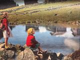 deux enfants assis sur un rocher au bord de l'eau