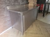 a stainless steel counter in the middle of a room
