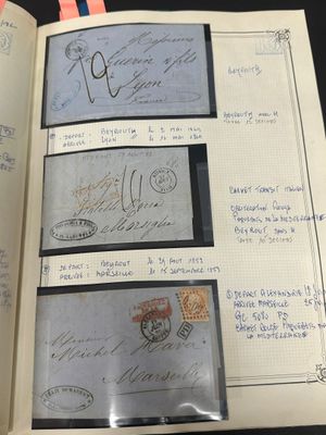un livre ouvert avec un tas de timbres posé sur une table