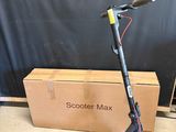 an electric scooter with a box on the ground next to it