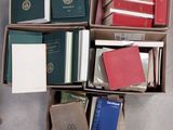 des boîtes de livres sont empilées sur le sol
