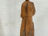 an image of a wooden sculpture of a woman standing on a block