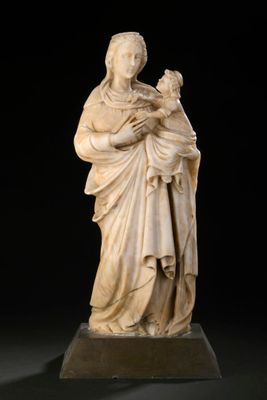 une statue en marbre blanc représentant une femme tenant un enfant dans ses bras