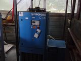 a blue machine sitting in a room next to a window