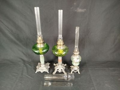 three green glass candlesticks on a clear stand with a black background