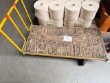 many rolls of toilet paper on a cart in a warehouse