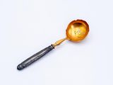 an old spoon with a handle that has a gold leaf on it