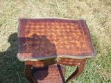 une petite table avec un plateau en bois posée sur l'herbe
