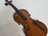 un gros plan d'un violon posé sur une surface blanche