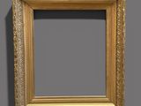 an old gold frame with a shadow on a gray background