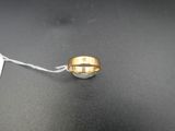 un gros plan d'une bague suspendue à un fil, avec une étiquette de prix