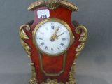 une horloge rouge et dorée posée sur une table
