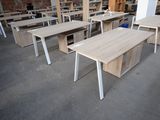 many desks and chairs in a room with a brick wall