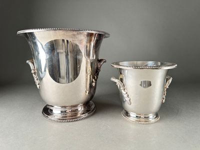 two silver vases sitting next to each other on a table