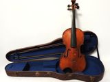un vieux violon posé dans son étui sur une surface blanche