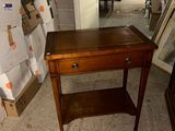 a small table with a drawer on it in a room