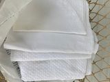 a basket full of folded white towels on a table