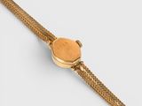 a close up of a gold watch with a chain around it