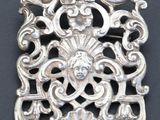 une broche en argent sur un fond noir
