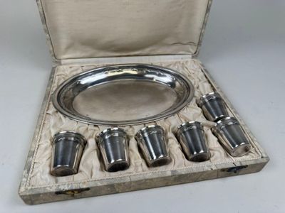 a silver plate with six cups in it in a case
