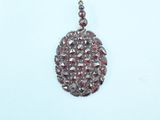 silver plated pendant with red and white stones on a white background
